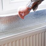 A radiator reflector is placed behind the radiator for thermal insulation.