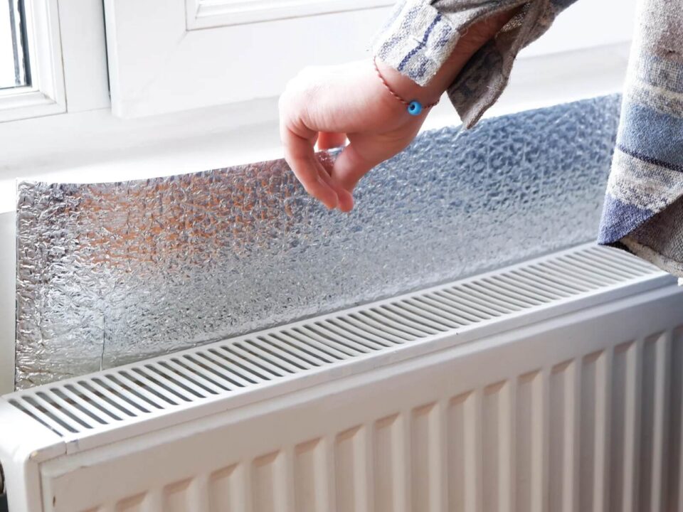 A radiator reflector is placed behind the radiator for thermal insulation.